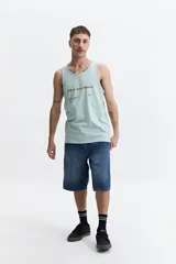 Musculosa de algodón color verde agua, con cuello redondo y estampado frontal con la frase 'Amplify your strength'.