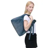 Cartera de hombro tipo slouchy de Marc Jacobs modelo The Sack Bag, confeccionada en denim azul con el nombre de la marca y del modelo estampado en color blanco en el lateral. Posee diseño holgado y correa integrada con detalles de tiras colgantes.