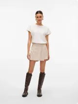 Pollera short de tiro alto y fit holgado, con diseño envolvente en la parte delantera y cierre lateral invisible.