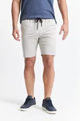 Bermuda de gabardina color beige, con diseño de cinco bolsillos, cintura con elástico y cordón ajustable.