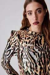 Remera de lycra con cuello redondo y manga larga abullonada con puño ajustado. Presenta estampado animal print con diseño de leopardo y cebra.