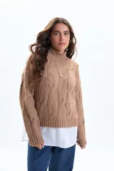 Sweater de punto en color beige con diseño de trenzas verticales, cuello alto acanalado y mangas largas con puños ajustados.