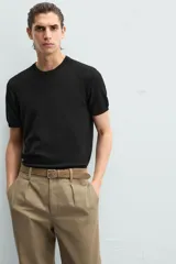 Camiseta negra de punto con cuello redondo, manga corta y corte regular. Tejido de viscosa con acabado en rib.