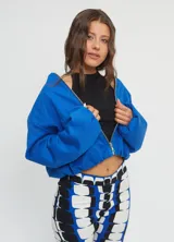 Campera tipo bomber color azul francia, con cuello a la base, cierre frontal completo, bolsillos ojal y mangas largas abullonadas. Confeccionada en gabardina de algodón.