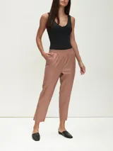 Pantalón negro de cuero sintético con cintura elastizada y corte tobillero.