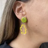 Aros colgantes con base circular rosa, detalle de strass y dije transparente con diseño abstracto celeste.