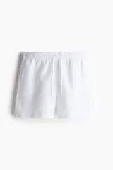 Short de baño blanco con cintura elástica y cordón de ajuste. Cuenta con bolsillos laterales, un bolsillo trasero con cierre autoadherente y suspensor interior de malla.