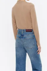 Camiseta marrón clara de manga larga, corte ajustado y cuello chimenea.