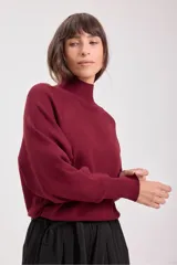 Sweater de punto color borgoña, con cuello alto y mangas ranglán.