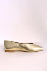 Ballerinas doradas con punta redondeada y suela plana color madera.