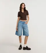 Blusa de cuello polo y manga corta, confeccionada en tejido rib de algodón con elastano. Presenta un diseño ajustado al cuerpo con escote en V y textura acanalada.