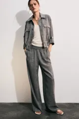 Pantalón gris melange de tiro alto y pierna ancha, con cintura elástica y bolsillos delanteros.