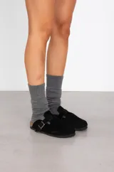 Zuecos de cuero con diseño de punta cerrada, ajuste con hebilla metálica lateral y suela anatómica de corcho.