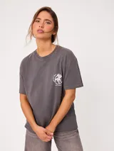 Remera de algodón color amarillo claro, con corte suelto y estampado gráfico en la espalda con diseño de muebles de playa y textos.