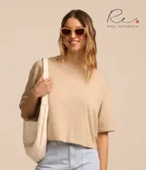 Remera cropped oversized de algodón peruano color beige, con cuello redondo y mangas cortas.
