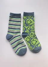 Pack de dos pares de medias de media caña. Un par a rayas horizontales de color gris, azul y verde. El otro par de color azul con estampado de caritas sonrientes de color verde.