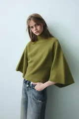 Jersey de punto color verde oliva, con cuello subido y mangas anchas tipo acampanadas.