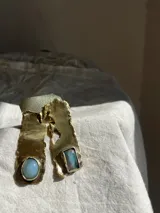 Aros colgantes de bronce reticulado con base irregular y piedra celeste redonda.