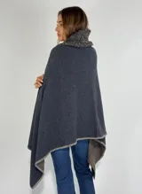 Ruana de lambswool color gris oscuro, con cuello alto y detalles bordados a mano en relieve en el cuello y a lo largo de la abertura frontal.