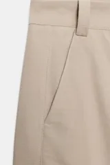 Pantalón barrel color azul marino, de tiro bajo, pernera holgada con diseño redondeado que se estrecha hacia el tobillo, con bolsillos delanteros y cierre frontal.