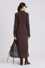 Vestido camisero largo color rojo oscuro, de manga larga y cuello camisero. Presenta un cierre frontal completo con botones oscuros y una abertura en el ruedo.