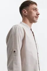 Camisa de hombre color gris con cuello mao, mangas largas y cierre abotonado. Confeccionada en algodón con look lino.