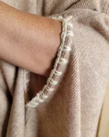 Poncho tejido tipo cashmere color camel con detalle de crochet en las mangas.