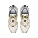 Championes Lacoste modelo Storm 96 2K, con diseño deportivo de estilo retro. Presenta una combinación de malla blanca y paneles superpuestos en tono dorado metalizado, con el logo del cocodrilo en el lateral. Suela robusta con detalles en gris y negro.