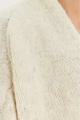 Saco abierto de punto en color beige, con diseño de manga larga y puños acanalados. Presenta un tejido con sutiles destellos brillantes integrados.
