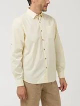 Camisa manga larga color amarillo pastel, confeccionada en popelina de algodón orgánico, con botones de madera, bolsillo en el pecho y protección UPF +20.
