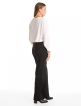 Pantalón de corte recto y tiro alto, confeccionado en tejido elastizado. Presenta una cintura con detalle de botones decorativos en los laterales.