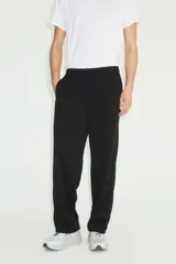 Jogger deportivo de corte relajado y piernas rectas, color negro, confeccionado en tejido funcional con tecnología DryMove. Cuenta con cintura elástica revestida con cordón de ajuste y bolsillos laterales insertados.