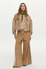 Campera de denim color camel, con diseño boxy, mangas abullonadas y volados frontales decorativos.