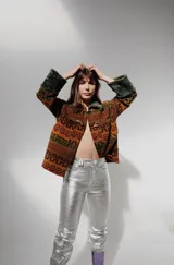 Pantalón de cuero tiro alto y corte recto, color turquesa metalizado, con cierre frontal y botón, bolsillos funcionales.