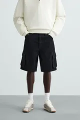 Bermuda de denim de algodón, color celeste lavado, de corte relajado (relaxed fit). Presenta cinco bolsillos, incluyendo bolsillos cargo plastrón con solapa en las perneras.