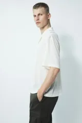 Pantalón cargo color verde oliva, de corte slim fit, con cintura elástica ajustable con cordón, bolsillos laterales al bies y bolsillos cargo con solapa y botón a presión en los muslos.