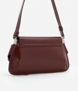 Cartera tipo baguette de tamaño pequeño, confeccionada en poliuretano color negro. Presenta una solapa frontal con detalles de hebillas metálicas decorativas en los laterales y un asa de hombro ajustable.