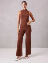 Top sin mangas color marrón con brillo, de cuello alto y corte ajustado.