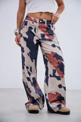 Pantalón de jean de tiro medio-bajo con corte recto y estampado tipo animal print de manchas irregulares en tonos beige, azul oscuro y terracota. Confeccionado en denim rígido sin elastano.