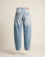 Jeans de corte barrel relajado, confeccionado en denim celeste claro con pespuntes y atraques a contratono en bordó. Presenta tiro medio, diseño de pierna curva y bolsillos traseros con logo bordado.