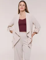 Chaqueta liviana color beige de silueta fluida y diseño abierto, con solapa caída, cintura con cordón ajustable y mangas 3/4 con presilla y argolla metálica.
