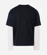 Remera de corte oversized con diseño de doble capa, que combina una remera negra de manga corta con mangas largas blancas integradas debajo. Confeccionada en algodón, presenta un estilo urbano y moderno.