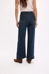 Jean de tiro alto en color azul oscuro, con costuras verticales decorativas en el frente y cierre de botón metálico.