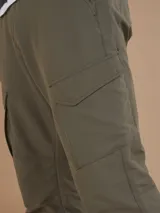 Pantalón negro de corte recto con bolsillos cargo laterales y cintura elástica.