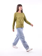 Remera negra de manga larga con cuello redondo y detalle de tachas doradas dispuestas en diagonal sobre el pecho.