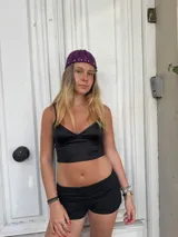 Gorro de crochet color violeta con tachas plateadas alrededor del borde.