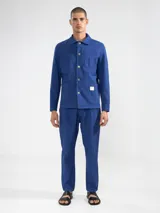 Pantalón azul de algodón con textura seersucker, corte recto, bolsillos laterales y traseros, cierre con botón y cremallera.