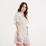 Mono corto con estampado floral celeste, escote cruzado, mangas cortas con volados y lazo en la cintura.