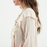 Camisa color crema con rayas verticales, cuello mao y volados en el frente.