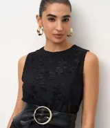 Vestido midi sin mangas, confeccionado en tejido jersey con textura floral flocada. Presenta cuello redondo y detalle de encaje en la espalda.